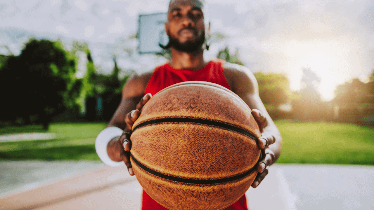 Basketball player holding ball on outdoor court, athletic training, sports performance, youth sports training, Prepathletics focus.