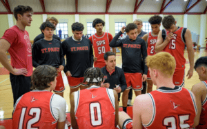 St. Paul’s basketball coach giving strategy talk to players in a huddle