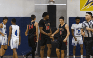 Knox School basketball players in black uniforms shake hands during a prep school game.