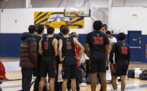 Knox School basketball players in black uniforms huddle with coaches during a prep school game.