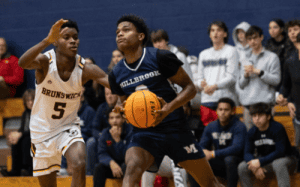 Millbrook player driving to the basket against Brunswick defender in high school game