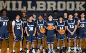 Millbrook basketball team posing in uniforms on home court