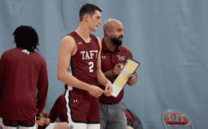 Taft basketball player with Coach Shavar Bernier discussing game strategy on the sideline.