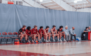 Taft basketball team lined up on the bench during a prep school basketball game.