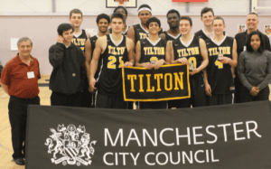 Tilton School boys basketball team holding a Tilton banner at a Manchester City Council tournament event.