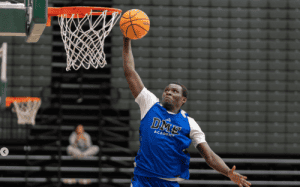 DME Academy basketball player dunks the ball during a high school game.