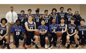 Hotchkiss School boys basketball team group photo with players and coaches in navy uniforms on the court.