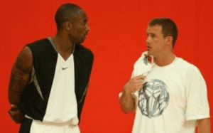 Kobe Bryant talking with Alan Stein Jr. during a basketball training session.