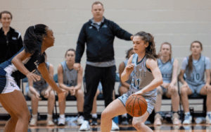 Western Reserve Academy girls basketball player dribbles the ball against a defender during a prep school game.