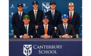 Canterbury School student-athletes pose in suits and college hats during National Signing Day, celebrating their college basketball and academic commitments.