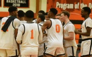 Hargrave Military Academy basketball players huddle together during a home game, celebrating their run to the BRAC Championship and VISAA Elite Eight berth.