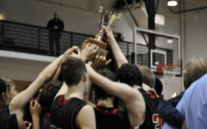 Hun School basketball players lift a championship trophy together in celebration after a hard-fought prep school victory.