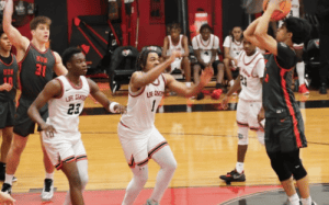Hun School basketball player shoots over defenders during an away game against Westtown School, showcasing focus and team execution.