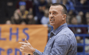 Chris Herren speaks passionately courtside during a basketball event, emphasizing early intervention and athlete mental health awareness.
