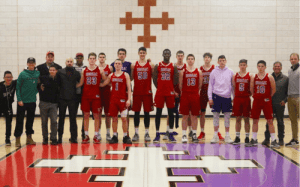 Hoosac School basketball team and staff stand together on the court for a group photo representing the International Sports Academy.