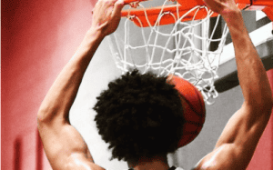 Basketball player finishing at the rim with power, emphasizing strength, vertical athleticism, and finishing ability developed through consistent training.