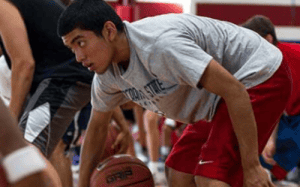 Basketball player working on ball-handling and stance during a focused training session, emphasizing daily skill development, conditioning, and attention to detail.
