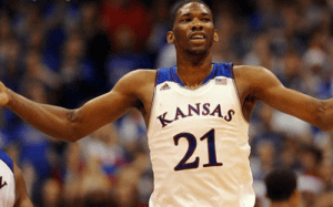 Division I basketball player celebrating on the court in a packed arena, representing elite physicality, confidence, and impact at the highest college level.
